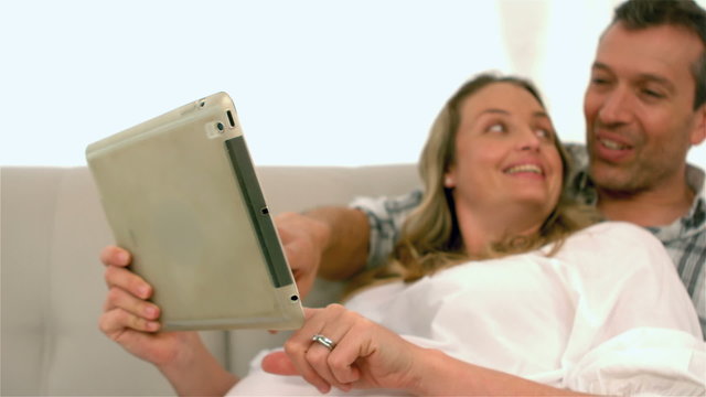 Happy future parents using tablet