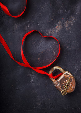 Padlock with key and a red ribbon ,the symbol of love.The background to the Valentine's day.selective focus.