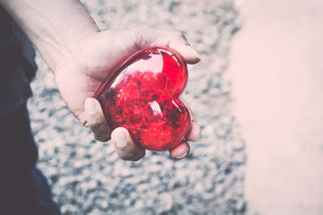 Male's hands holding red heart