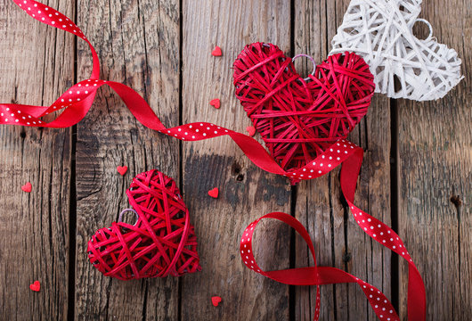 Heart decorated with a red ribbon for a romantic Valentine's day celebration, on vintage wooden background.selective focus.
