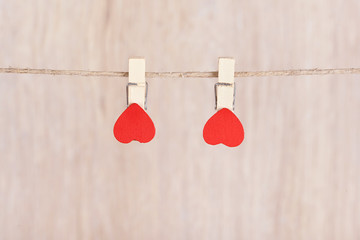 Two red hearts hung on the rope