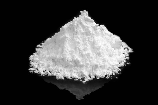 heap of white powder on black background