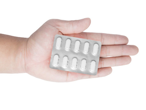 blister pack of pills in hand isolated on white