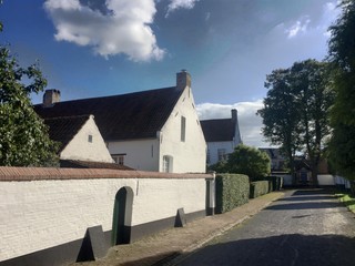 Whitewashed houses and a white wall along a cobbled street in the beguinage of Hoogstraten, Belgium © Bjorn B
