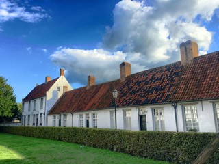 Row of whitewashed houses with red tiled roofs and chimneys in the beguinage of Hoogstraten, Belgium © Bjorn B