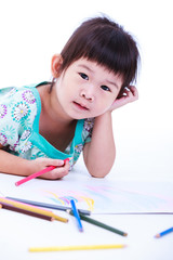 Child lie on the floor and drawing on paper. On white