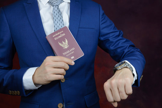 businessman showing passport, check time on watch