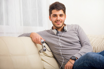 Young guy enjoying computer game, playing with joystick, smiling 