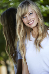 Naklejka premium Smiling young woman with long blond hair, portrait