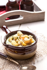 Homemade cauliflower soup in a brown bowl.