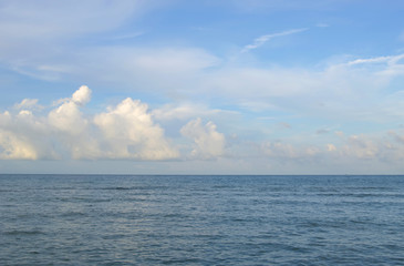Obraz premium marine background, serenity shade water, picturesque blue clouds sky above horizon line 