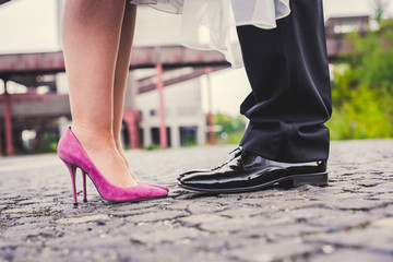 Brautschuhe und die Schuhe des Bräutigams in dem Ambiente von Industriekultur
