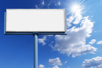Blank Billboard Against a Blue Sky / Big empty billboard with blue pole on a blue sky with clouds and sun rays