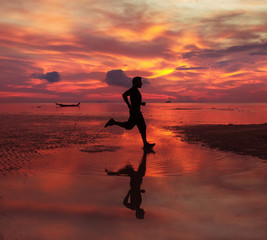  jogger on sunrise along the sand beach with mirror on the water