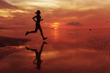  jogger on sunrise along the sand beach with mirror on the water