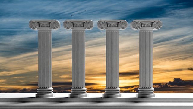 Four ancient pillars with sunset sky background.