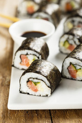 Fish and vegetable sushi on white plate