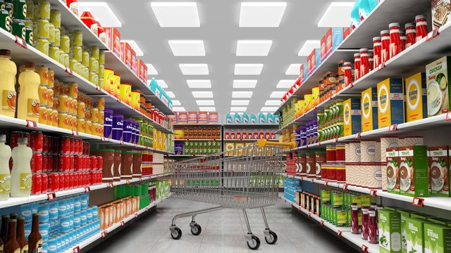 Supermarket interior with shelves full of various products and empty trolley basket