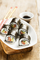 Fish and vegetable sushi on white plate