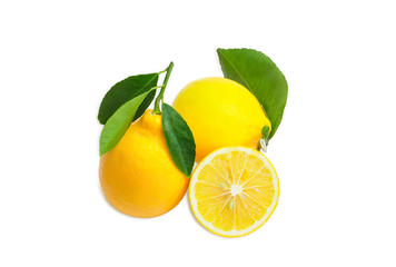 Two whole lemons with leaves and one cut lemon