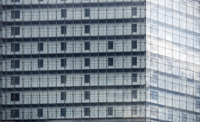Exterior of a multistory office building. Close-up fragment of the facade of a modern building with large glass windows. Modern architecture.