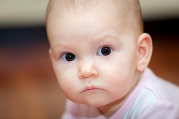 Close-up of a small child who cries but does not scream. A tear rolling down his cheek. Blurred background. Photo girl.