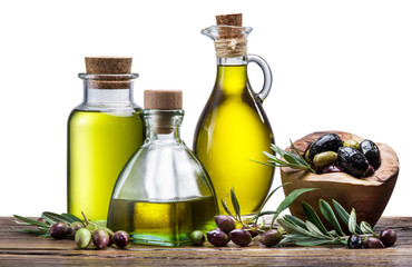 Olive oil and berries on the wooden table.