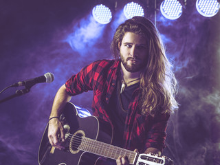 Playing acoustic guitar on stage