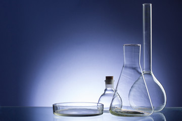 Assorted empty laboratory glassware, test-tubes. Blue tone medical background. Copy space for text.