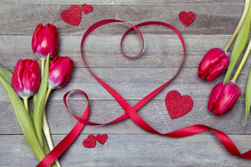beautiful valentines day background with ribbon heart and fresh red tulips
