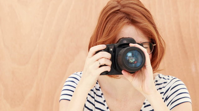 Smiling hipster woman taking picture with camera
