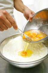 玉子をボウルの小麦粉と混ぜる