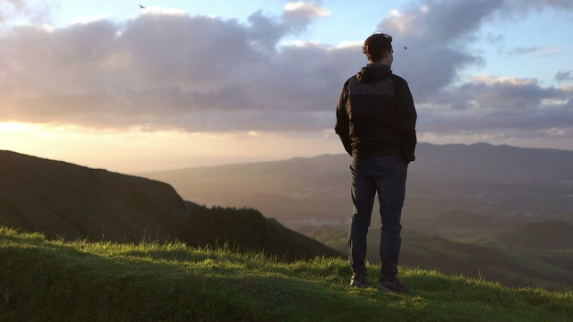 Caucasian man watching birds in the air flying during golden hour
