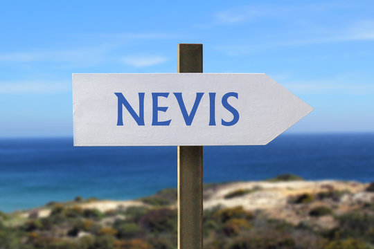 Nevis sign with seashore in the background