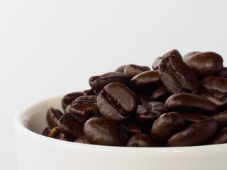 Pile of roasted coffee beans in Cup