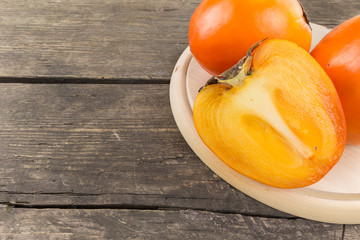 Persimmon fruit on a rustic wooden background. Food series.