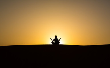Obraz na płótnie Canvas silhouette of a man sitting in a pose against the sky