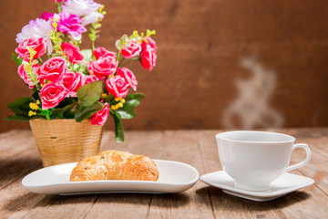 hot coffee and croissant on wooden