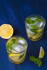 Glasses of lemonade with lemon, lime and mint