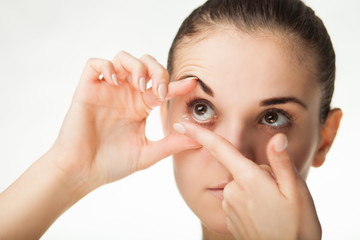 Woman putting contact lens in her eye