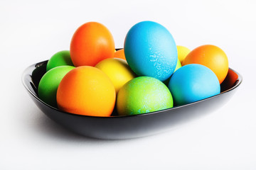Easter eggs in a black ceramic plate. Shallow depth of field. Selective focus.