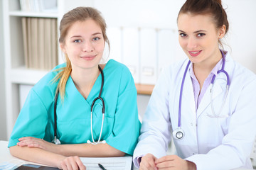 Female doctor  and young surgeon intern in hospital