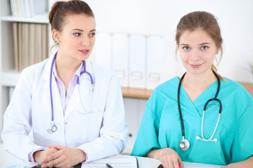Fototapeta premium Female doctor and young surgeon intern in hospital
