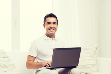 happy man working with laptop computer at home