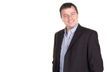 Happy smiling man leaning against white wall with