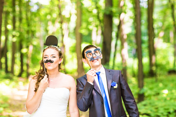 April Fools' Day. Wedding couple posing with stick lips, mask. 