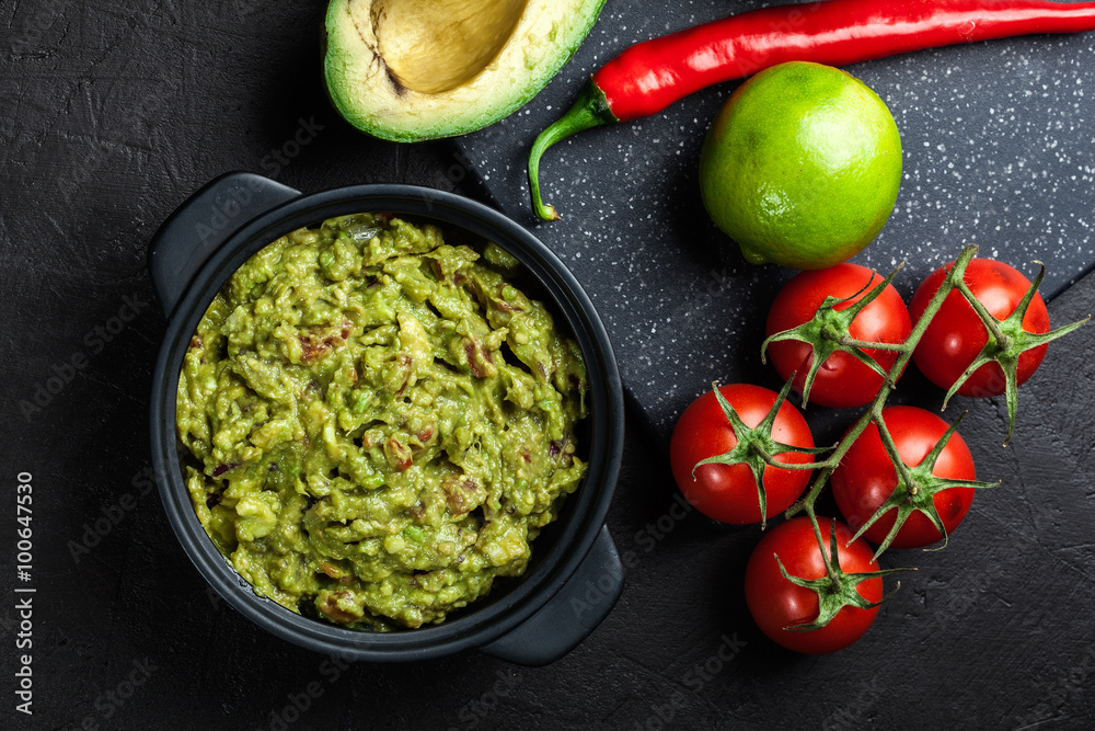 Wall mural Bowl of guacamole with fresh ingredients