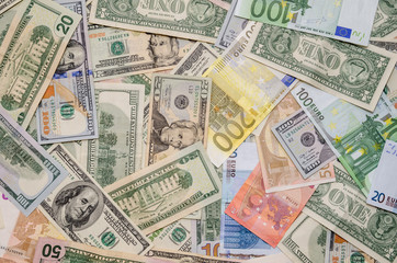 Pile of two leading currencies - US Dollar versus Euro as background