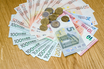 Top view of Euro coins and banknotes  on wooden table