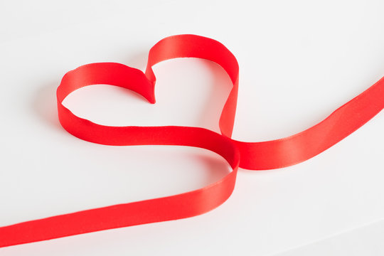 Red ribbon heart shape on white background